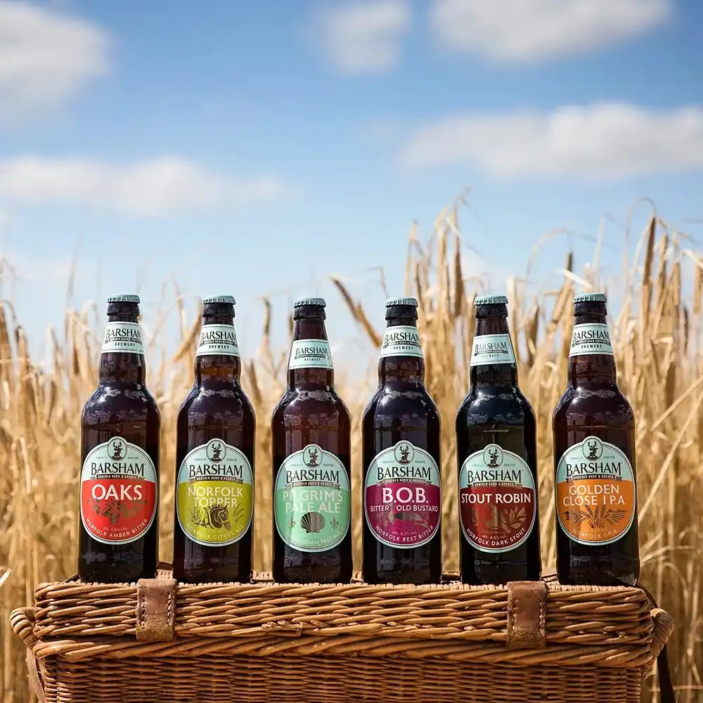 Six Barsham Brewery beers displayed in a basket in a field