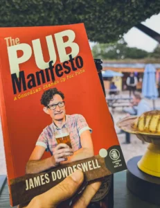 A copy of The Pub Manifesto by James Dowdeswell beside a CóMeme UFO at Barsham Brewery
